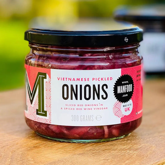 Manfood Vietnamese pickled onions in a jar, showcasing vibrant sliced onions immersed in tangy pickling liquid.