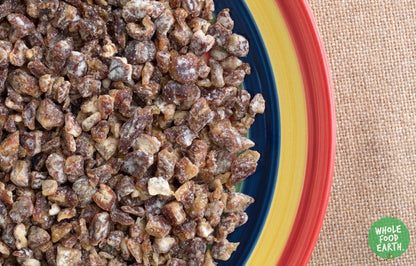 Chopped dried dates from Whole Food Earth, GMO-free, vegan, dairy-free, with no added sugar, in a clear container.