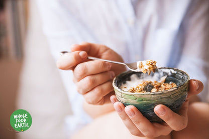 Whole Food Earth Deluxe Muesli cereal featuring flakes, dried fruit, nuts, and seeds in a natural, GMO-free, vegan, dairy-free blend.