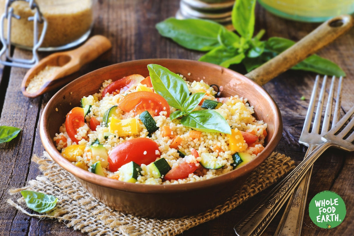Raw organic spelt couscous from Whole Food Earth, GMO-free, vegan, and additive-free, displayed in a bowl with a spoon.