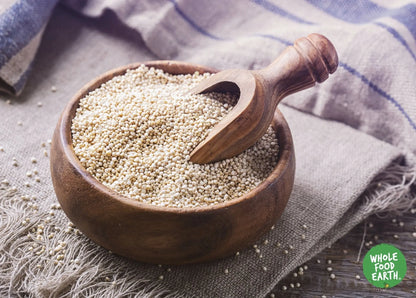 Raw organic quinoa grains from Whole Food Earth, GMO-free, in a clear bowl showing light, fluffy quinoa suitable for cooking.