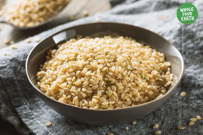 Organic short grain brown rice from Whole Food Earth, GMO-free, showing cooked and uncooked rice grains in a bowl and bag.