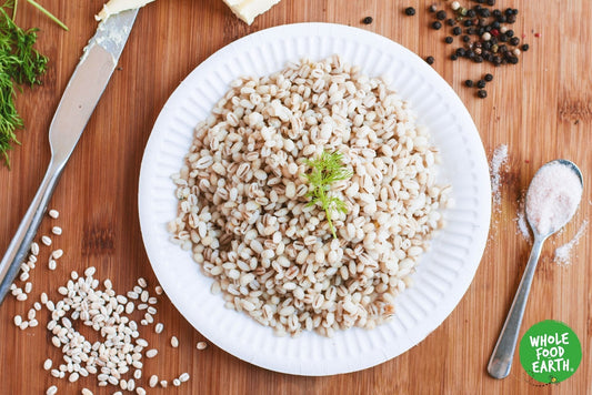 Whole Food Earth Pearl Barley in a clear bowl, showing its round, light-colored grains, GMO-free, vegan, and dairy-free flour and grain product.