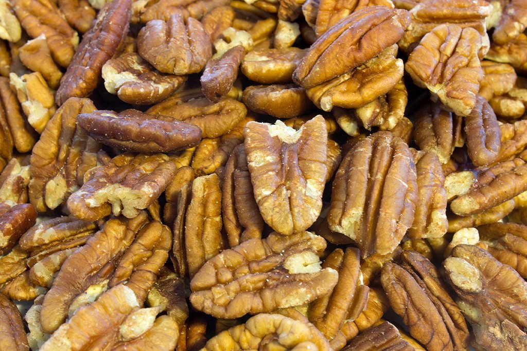 Raw Whole Food Earth pecan halves, GMO-free nuts and seeds in a natural light setting.