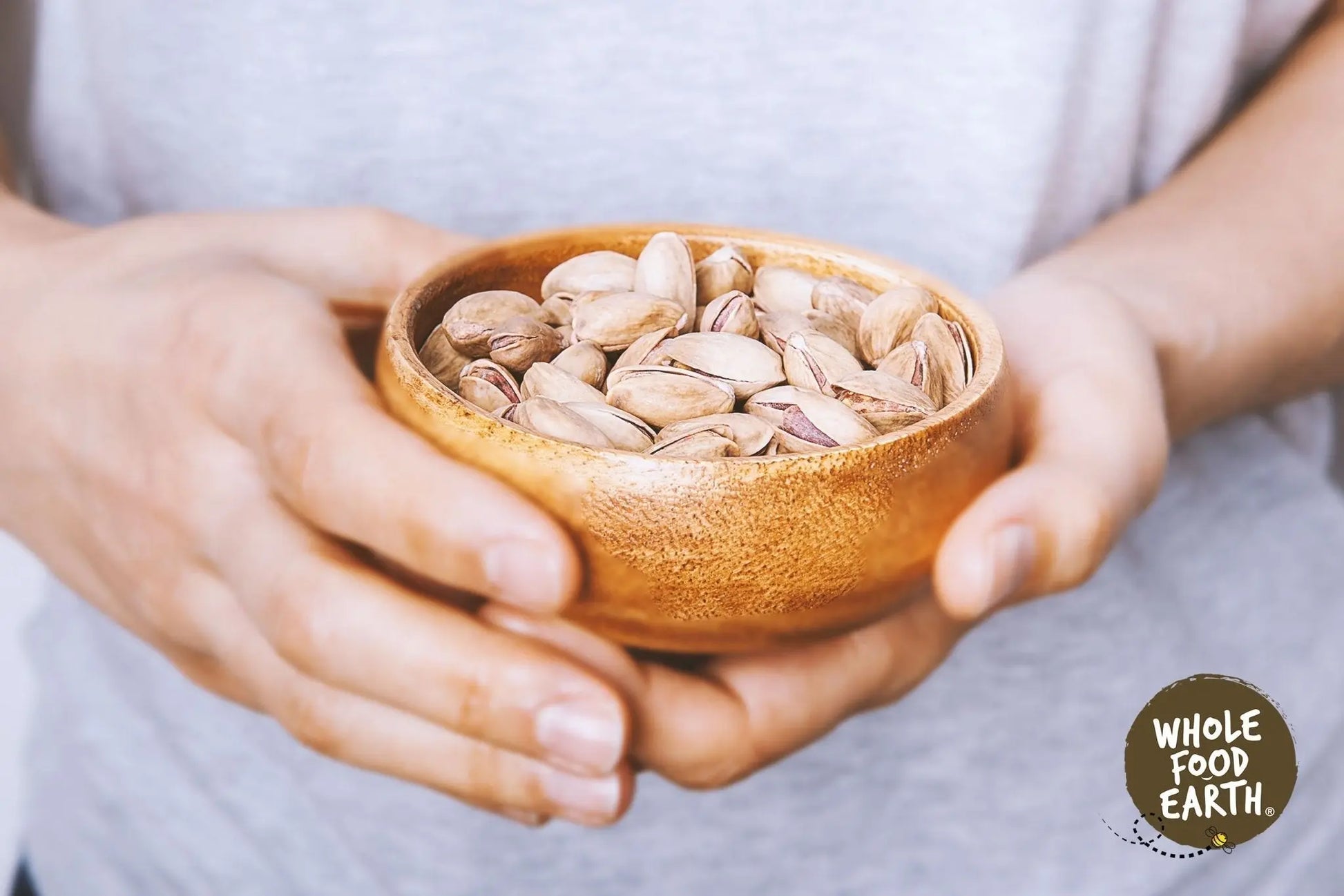 Roasted and salted pistachios in a bowl, Whole Food Earth brand, GMO-free nuts and seeds.