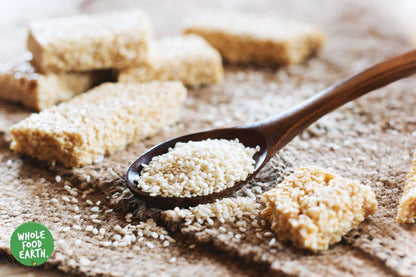 Unhulled sesame seeds from Whole Food Earth, natural and GMO-free, shown in a close-up image, ideal for cooking and baking.