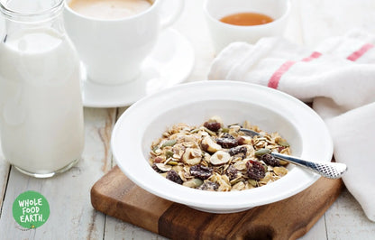 Whole Food Earth Super Deluxe Muesli with chopped nuts, dried fruit, seeds, and flakes in a bowl, vegan and dairy-free cereal mix.
