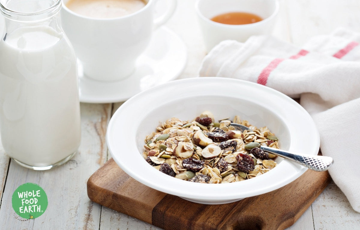 Whole Food Earth Super Deluxe Muesli with whole nuts, dried fruit, seeds, and flakes in a bowl, GMO-free vegan cereal.