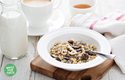 Whole Food Earth Super Deluxe Muesli with whole nuts, dried fruit, seeds, and flakes in a bowl, GMO-free vegan cereal.