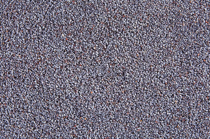 Unwashed raw poppy seeds from Whole Food Earth, GMO-free, showing small blue-gray seeds in a natural pile.