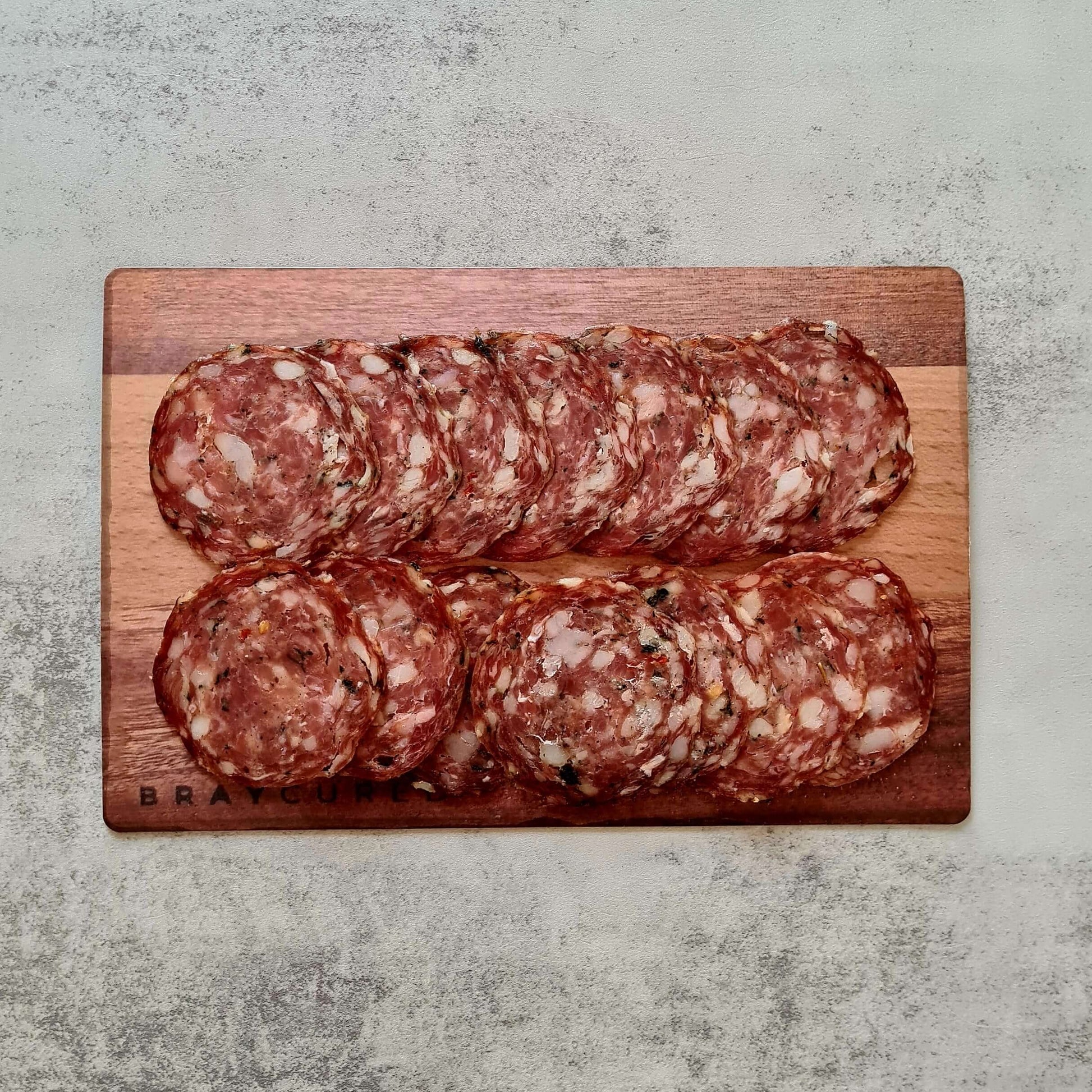 Bray Cured Bacchus Brut charcuterie hamper with wild garlic salami, assorted British cured meats, and gourmet accompaniments on a wooden board.
