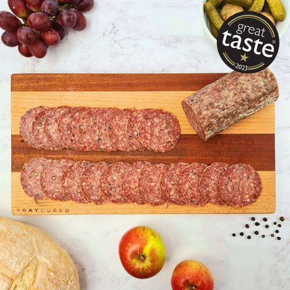 Bray Cured Wild Garlic Salami slices on a wooden charcuterie board, showcasing its rich texture and wild garlic flavor.