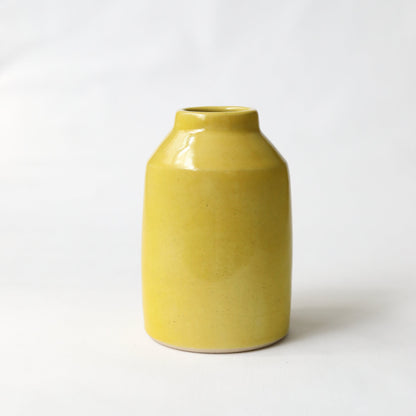 Sun yellow classic bud vase by Katie L Thompson Designs on a white background, ideal for holding small floral arrangements.