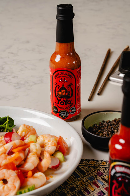 Spicy "EXTRA HOT" YoYo Laos Sauce Ginger Chilli Sauce in a glass jar, showcasing vibrant red chili and ginger ingredients.