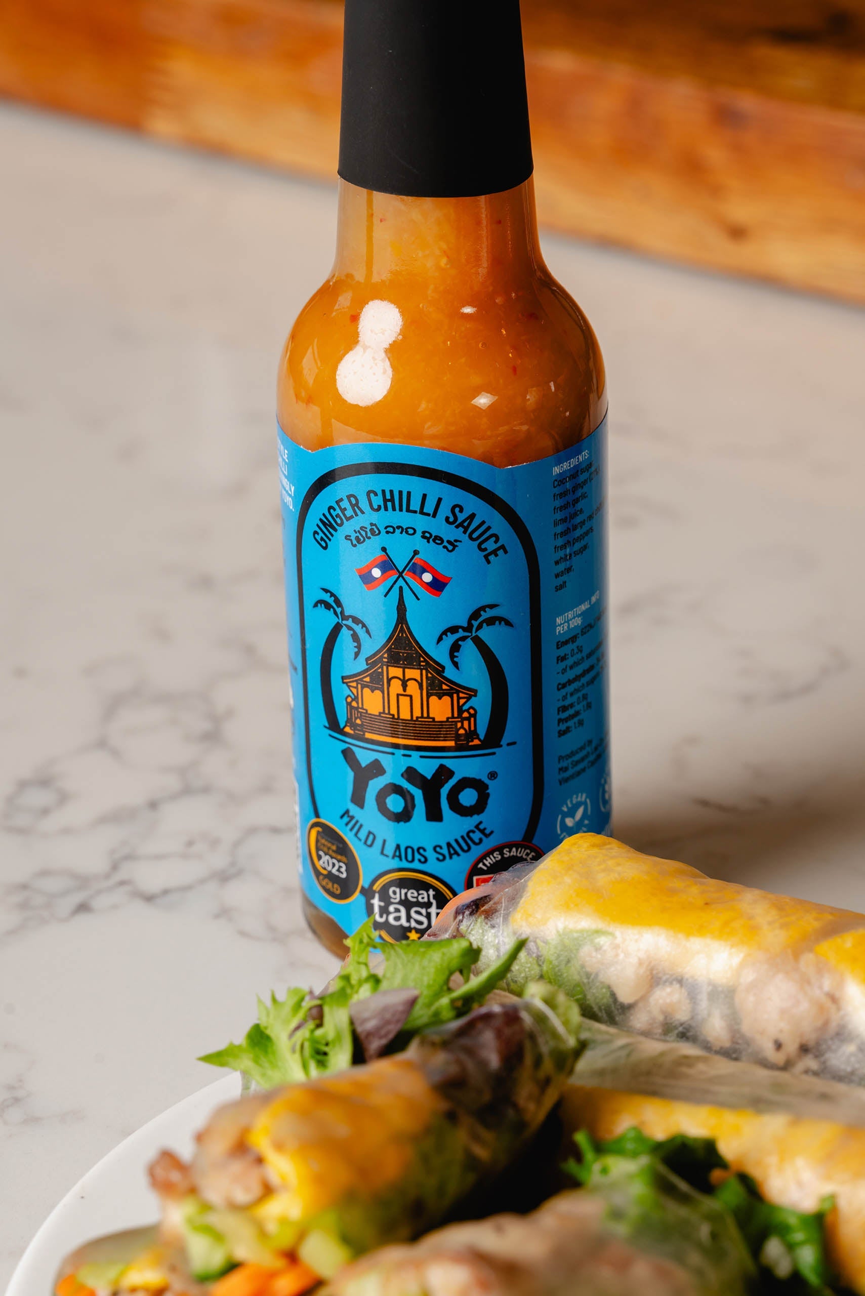 Bottle of YoYo Laos Sauce Mild Ginger Chilli Sauce, a signature sauce with vibrant label, showcasing the spicy ginger chili flavor.